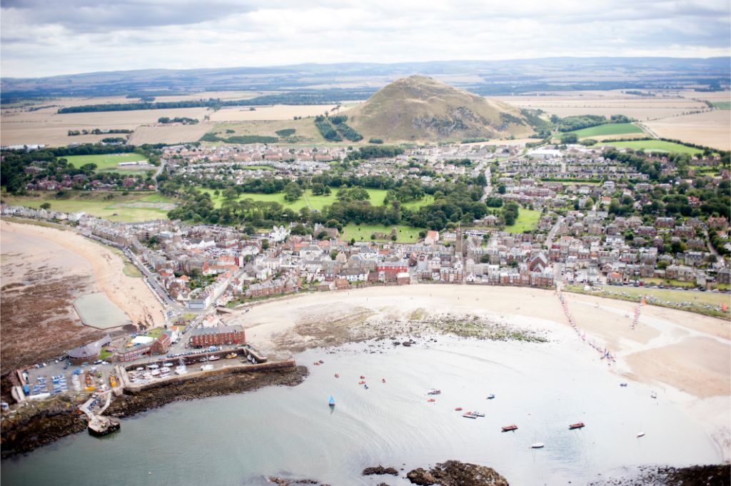 An aerial view of the town of North Berwick from the sea with North Berwick Law in the background