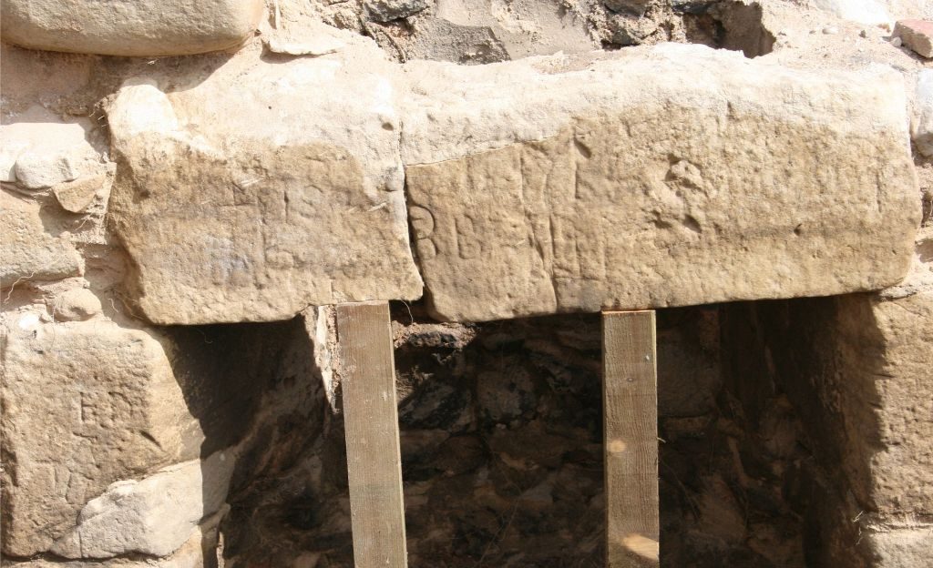 A stone lintel with marks carved into the face
