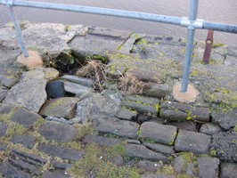 Cobble erosion and new rail at end of pier.  Photo taken facing south