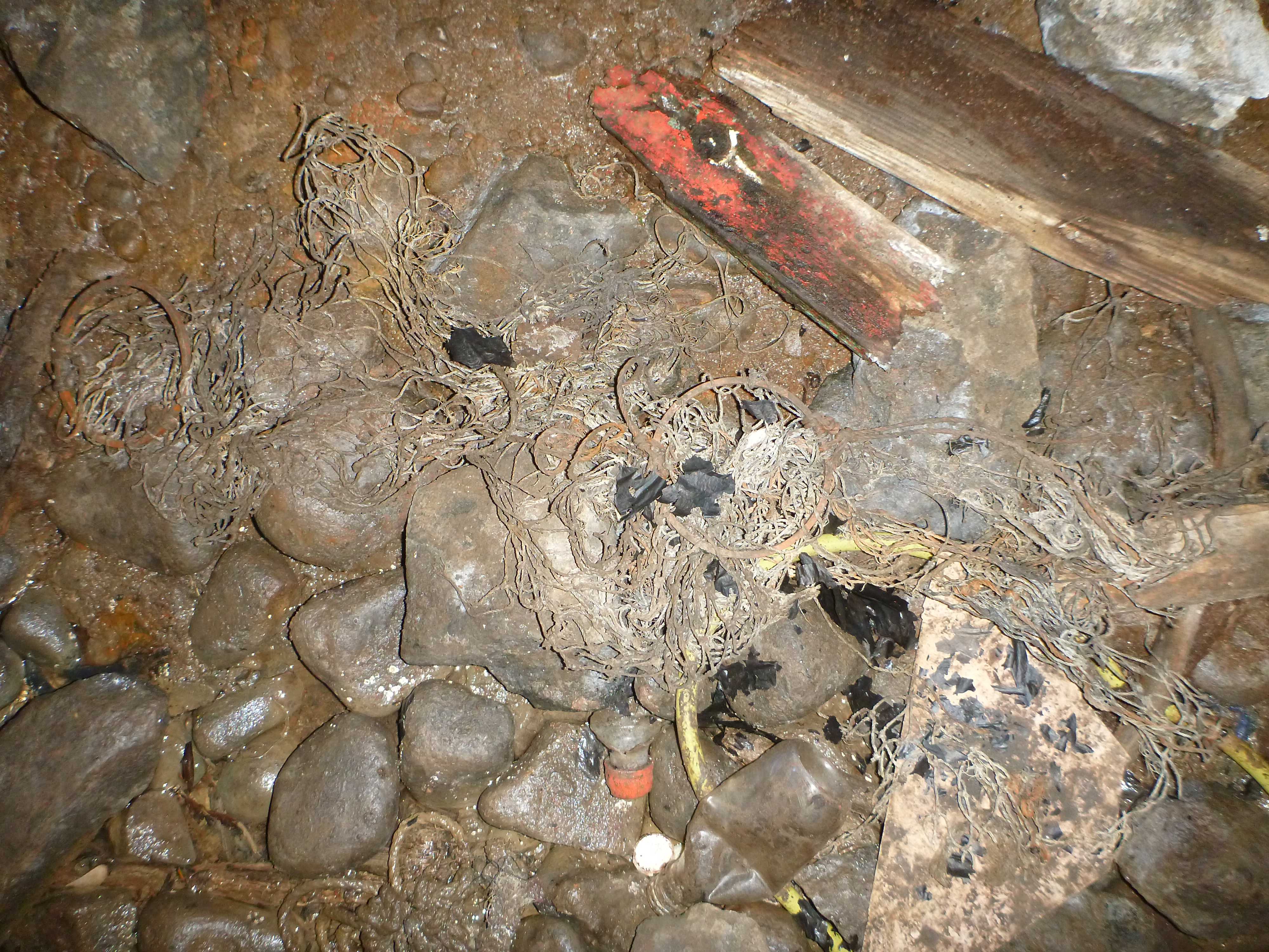 Objects and rubbish on floor of rear cavern