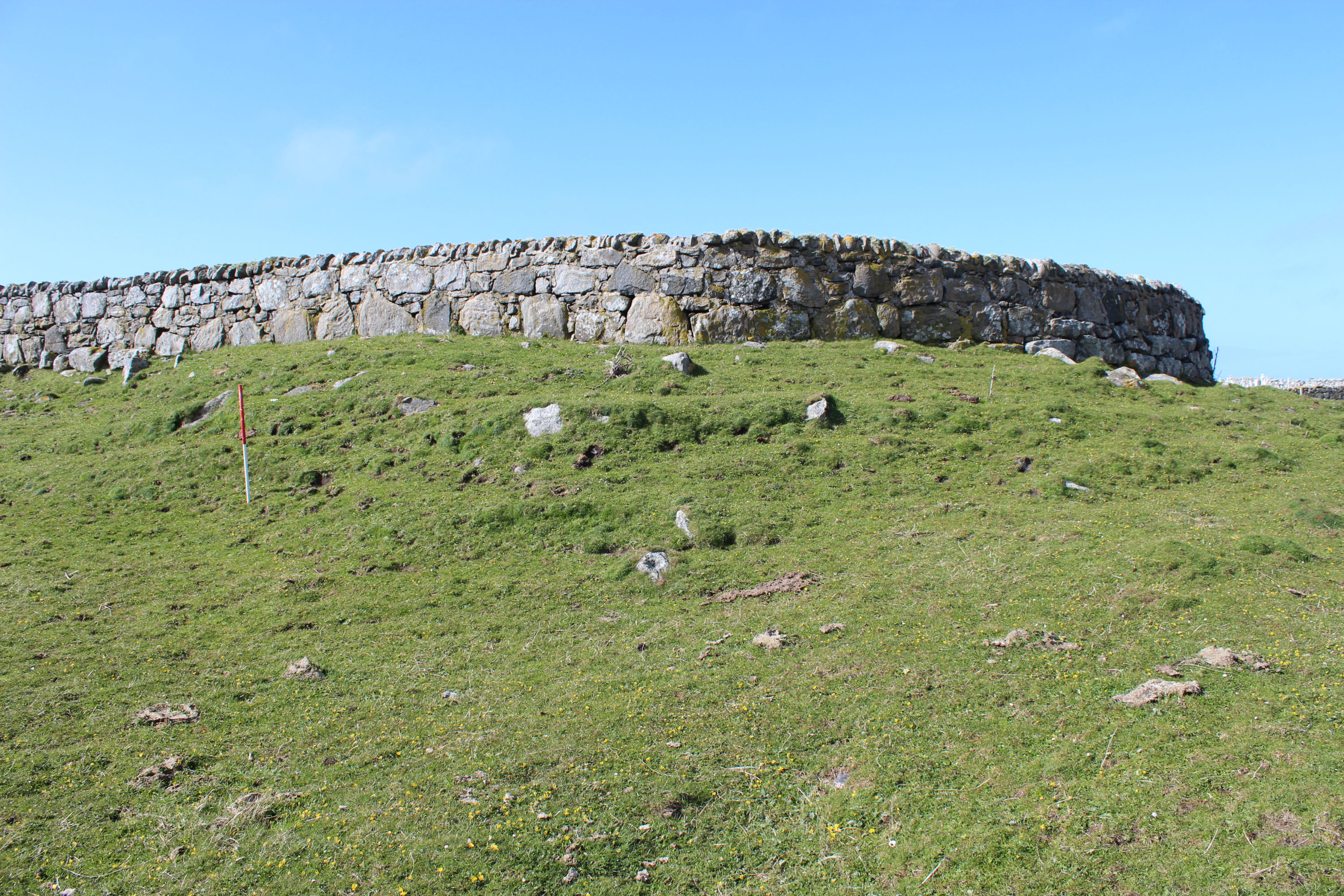 General view of the broch mound with cemetery wall on top