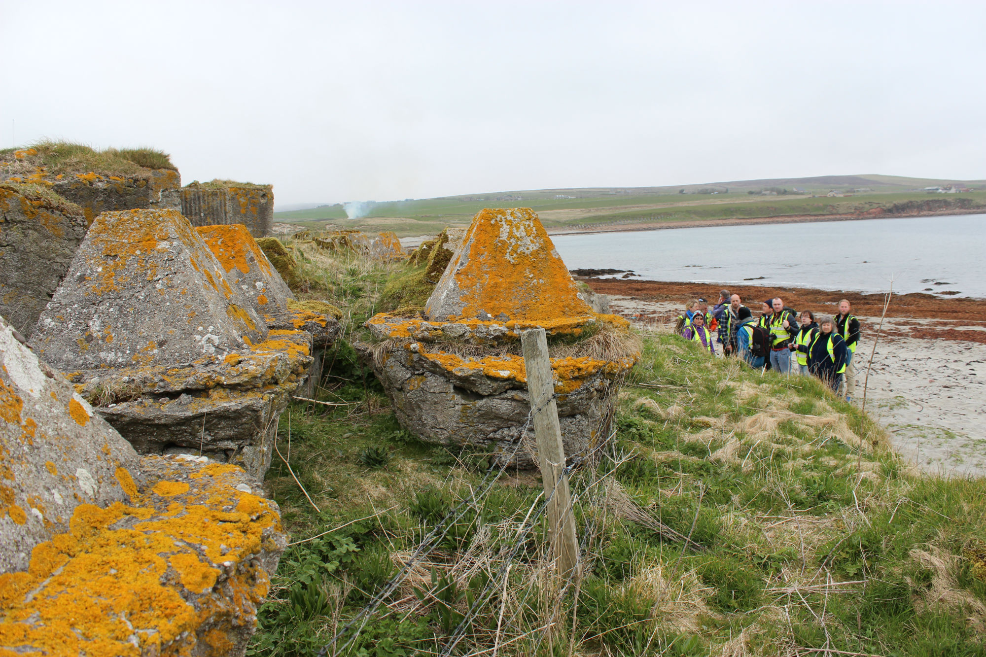 Anti-tank defences undermined by erosion at coast edge with foundations exposed