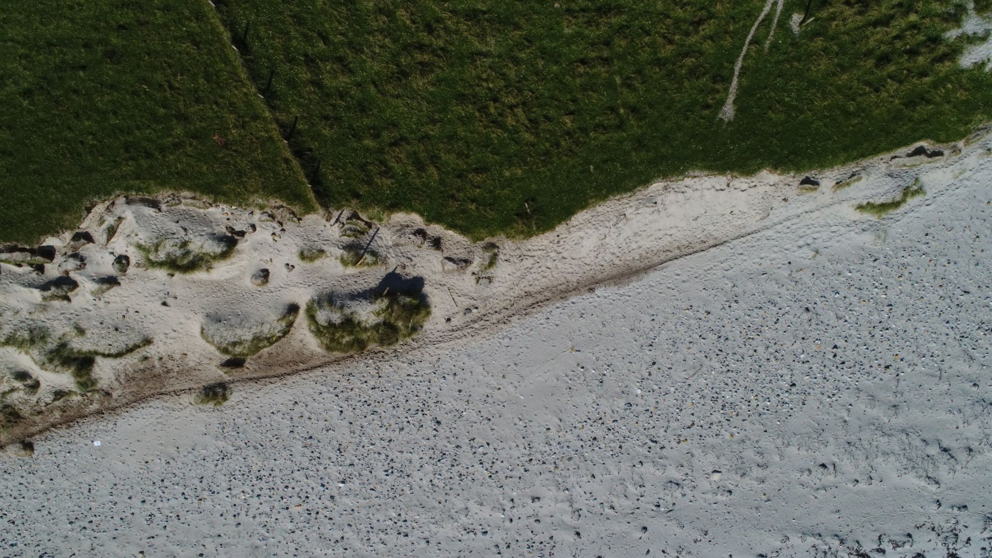 May 2018: aerial view of eroding coast edge with extensive midden desposits
