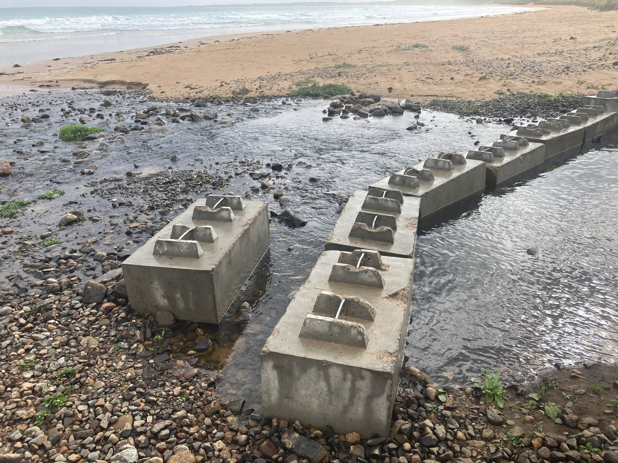 Eight concrete blocks at mouth of culvert.  Look to be more modern than WW2 anti-tank blocks.