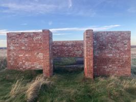 Opening of northern red bricked walled structure, containing concrete plinth. Looking north.