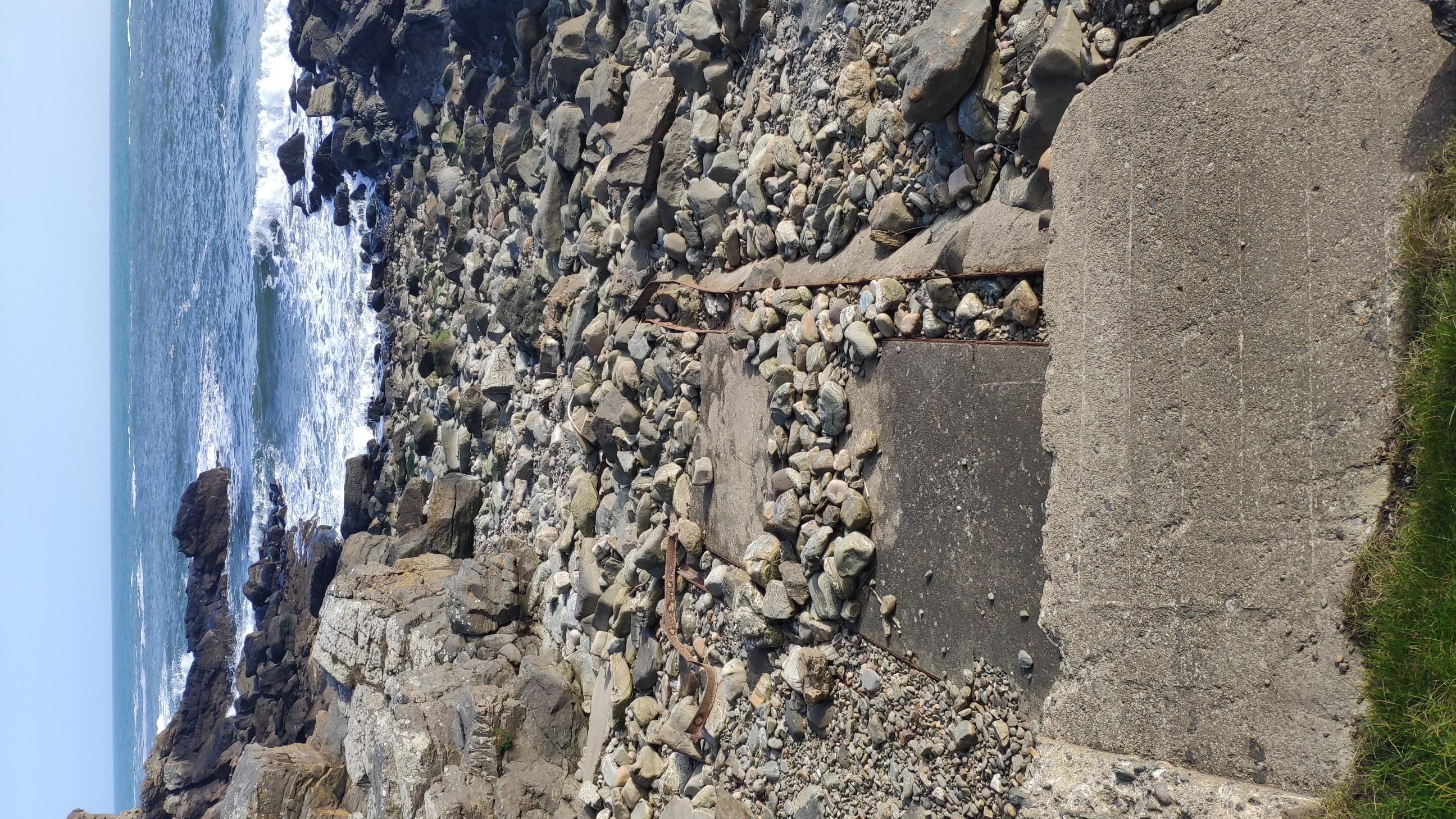 Concrete slipway with remains of iron rails.