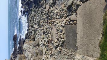 Concrete slipway with remains of iron rails.