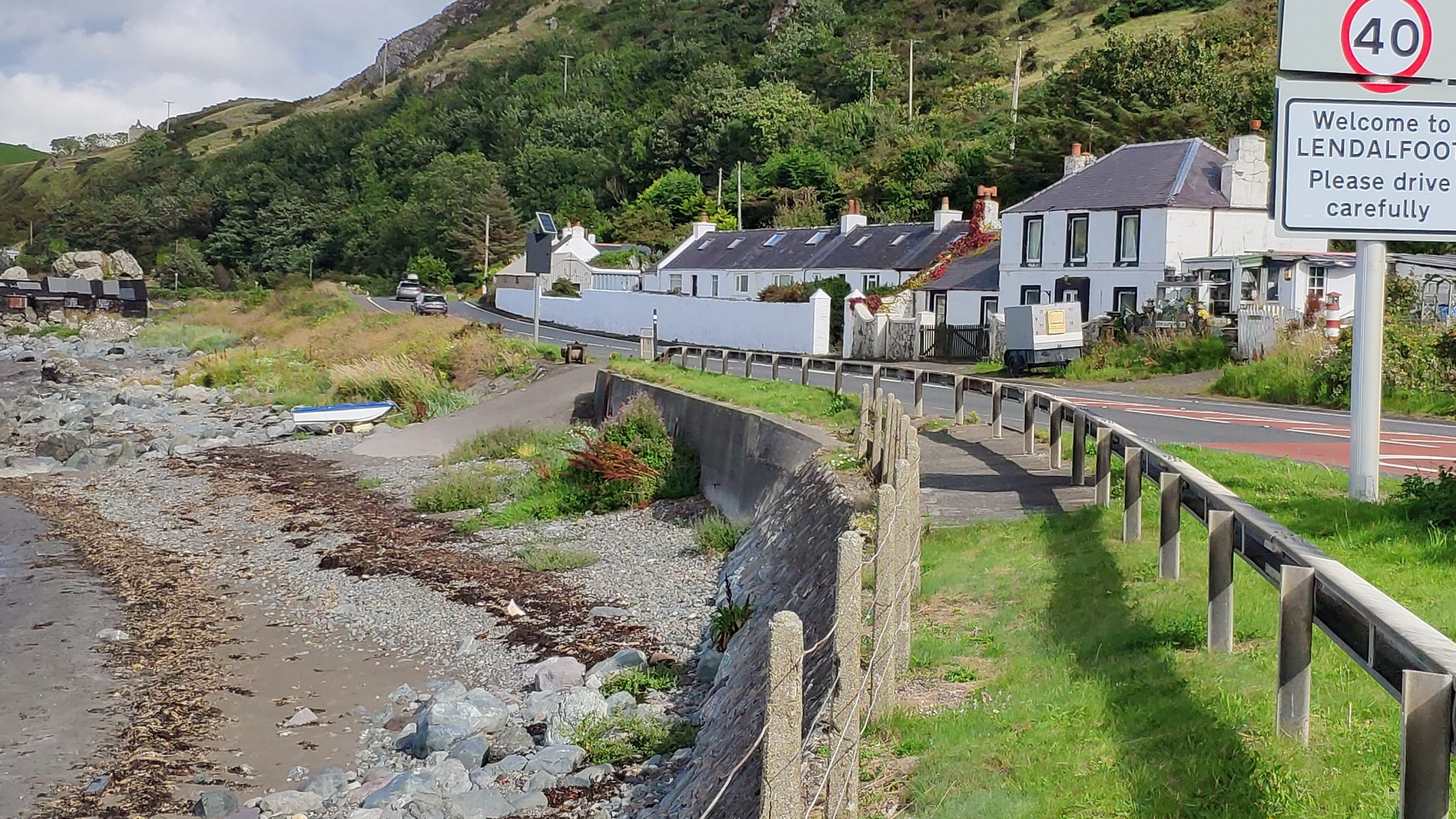 General view of Lendalfoot, with view of terraced cottages, slipway with winch and old fishing sheds by the shore.