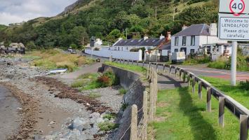 General view of Lendalfoot, with view of terraced cottages, slipway with winch and old fishing sheds by the shore.