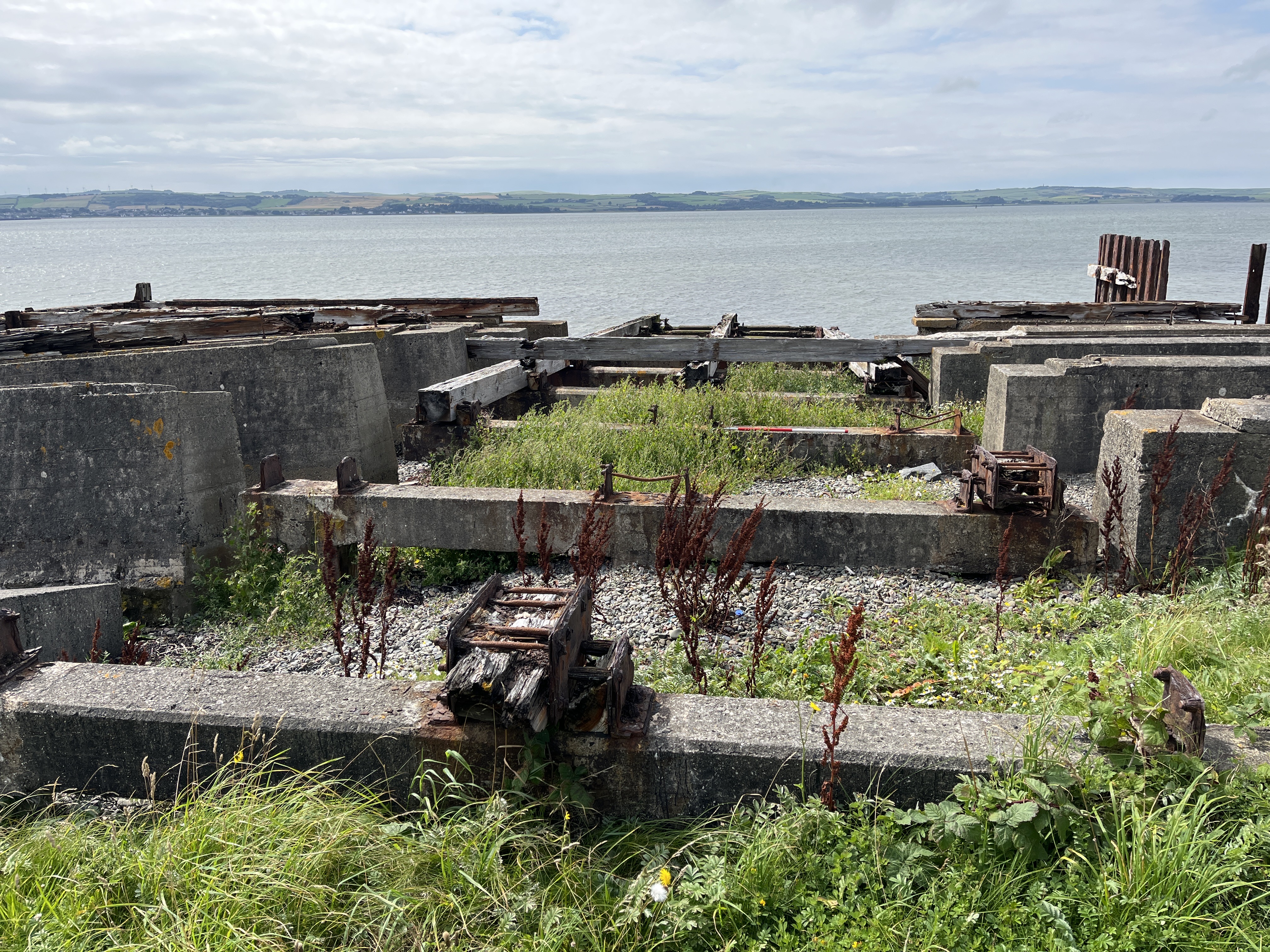 Timber and concrete slipway with remains of cast iron fixings, looking west. Location 1 on site map.